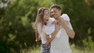 Aşk doğada kucaklayan içinde güzel bir çift. Mutlu kadın ve sarılma ve hafta sonu yaz tadını çıkarırken yakışıklı genç adam portresi. Romantik Tarih açık havada insanlar