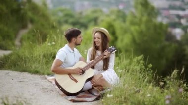Güzel çift romantik Tarih, birlikte vakit doğada aşık. Sırasında müzik keyfi güzel gülümseyen kadın gitar çalmak yakışıklı genç adam. İnsanlar piknik Park