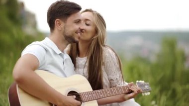 Güzel çift romantik Tarih, birlikte vakit doğada aşık. Sırasında müzik keyfi güzel gülümseyen kadın gitar çalmak yakışıklı genç adam. İnsanlar piknik Park