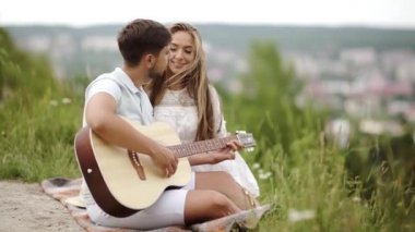 Güzel çift romantik Tarih, birlikte vakit doğada aşık. Sırasında müzik keyfi güzel gülümseyen kadın gitar çalmak yakışıklı genç adam. İnsanlar piknik Park