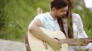 Güzel çift romantik Tarih, birlikte vakit doğada aşık. Sırasında müzik keyfi güzel gülümseyen kadın gitar çalmak yakışıklı genç adam. İnsanlar piknik Park