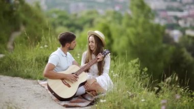 Güzel çift romantik Tarih, birlikte vakit doğada aşık. Sırasında müzik keyfi güzel gülümseyen kadın gitar çalmak yakışıklı genç adam. İnsanlar piknik Park