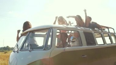 Seyahat. Arkadaşlar araba açık çatı eğleniyor. Retro otobüs ile dans mutlu gülümseyen genç insanlar araba çatı yaz gününde açın..