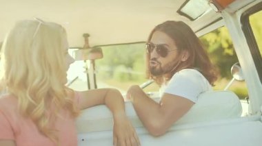 Arkadaşlar arabaya yaz aylarında seyahat, eğleniyor. Yaz seyahat zevk mutlu gülümseyen genç arkadaşlar. Yakışıklı ve güzel kadının Retro otobüs ve yaz tatili.