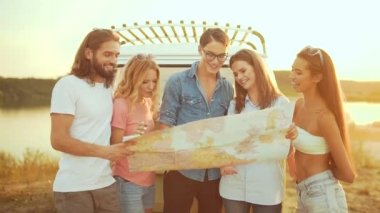 Yaz seyahat. Harita araba yakınındaki doğada kullanarak arkadaşlar. Mutlu gülümseyen insanlar otobüs içinde hafta sonu tatil seyahat. Güzel genç erkek ve harita tutarak, gezisinde yer keşfetmek.