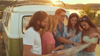Yaz seyahat. Harita araba yakınındaki doğada kullanarak arkadaşlar. Mutlu gülümseyen insanlar otobüs içinde hafta sonu tatil seyahat. Güzel genç erkek ve harita tutarak, gezisinde yer keşfetmek.