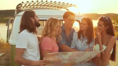 Yaz seyahat. Harita araba yakınındaki doğada kullanarak arkadaşlar. Mutlu gülümseyen insanlar otobüs içinde hafta sonu tatil seyahat. Güzel genç erkek ve harita tutarak, gezisinde yer keşfetmek.