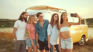 Yaz aylarında doğada telefonda fotoğrafta arkadaşlar. Mutlu genç erkekler ve yaz seyahat etmek tatil zevk, eğlence vakit Retro otobüs açık havada birlikte yakınındaki güzel kadın.