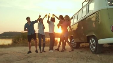 Dans ve doğada içme genç arkadaşlar. Güzel mutlu insanlar içecekler yaz hafta sonu eğleniyor. Retro otobüs yakınındaki dış taraf zevk arkadaş.