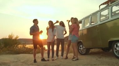 Dans ve doğada içme genç arkadaşlar. Güzel mutlu insanlar içecekler yaz hafta sonu eğleniyor. Retro otobüs yakınındaki dış taraf zevk arkadaş.
