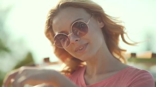 美丽的女孩在太阳镜下享受夏日的阳光 快乐的微笑的女人在风中旅行在露天屋顶在汽车 享受周末旅行 — 图库视频影像