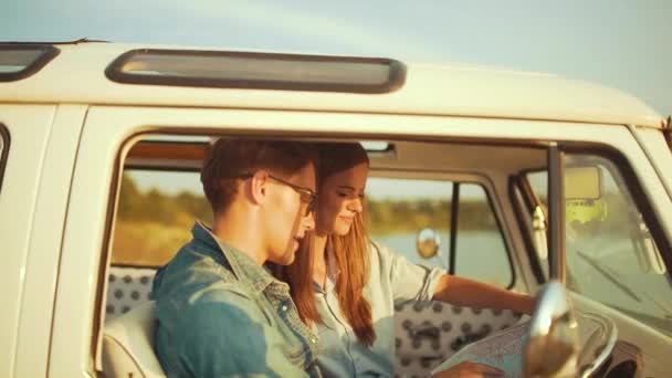 夏に車でマップを使ってカップル旅行 幸せな笑顔の若い人は夏休みの旅行を使用して地図表示 ハンサムな男と美女の旅行を持っていること — ストック動画