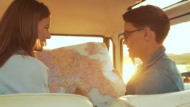 朋友们用地图在夏天驾车旅行 英俊的男人戴着眼镜 漂亮的微笑的女人在户外旅行时手里拿着地图 年轻人周末旅行 — 图库视频影像