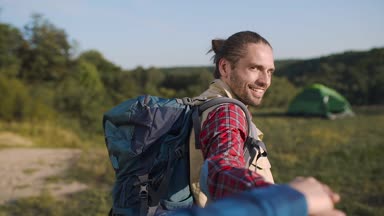 Doğada seyahat, seyahat etmek tatil üzerinde kadının elini tutarak sırt çantası olan yakışıklı turist adam.
