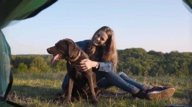 Kamp. Mutlu kadın ile köpek, çadır çimenlerin üzerinde oturan ve doğada yaz zevk seyahat.