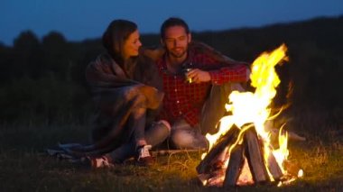 Romantik bir hafta sonu. Kamp ve şenlik ateşi sarılma ve tatil açık havada dinlenme yakınındaki aşık Çift.