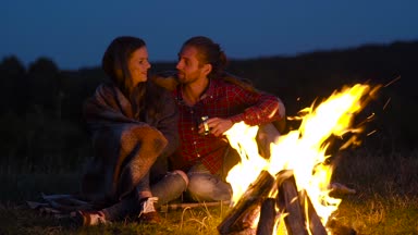 Romantik bir hafta sonu. Kamp ve şenlik ateşi sarılma ve tatil açık havada dinlenme yakınındaki aşık Çift.