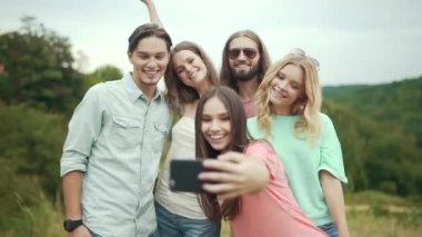 Genç erkek ve kadın telefon ve doğada vakit süre gülüyor fotoğrafları alarak gülümseyen.