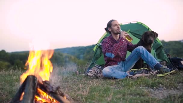 Man Reser Naturen Sitter Nära Lägret Och Brasa Med Hund — Stockvideo