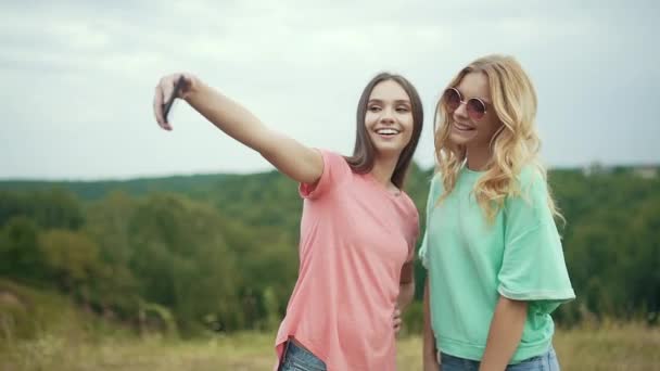 美しい女の子友達が楽しいと自然に笑いを持つ携帯電話で写真を撮って — ストック動画