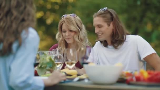 人们在餐桌旁吃着饮料欢呼着喝着户外晚餐派对 — 图库视频影像