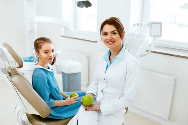 Tandkliniken. Kvinnliga tandläkare och lilla patienten äta äpple — Stockfoto