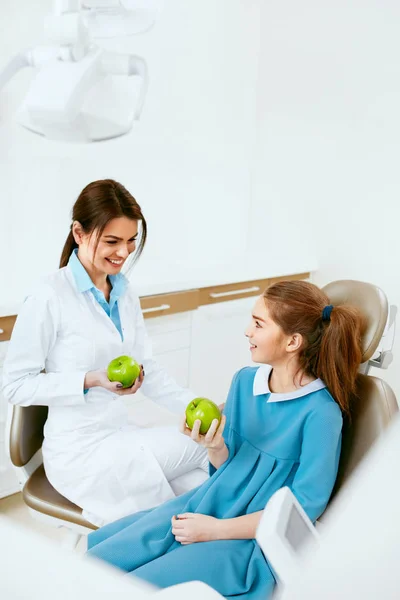 Tandkliniken. Kvinnliga tandläkare och lilla patienten äta äpple — Stockfoto