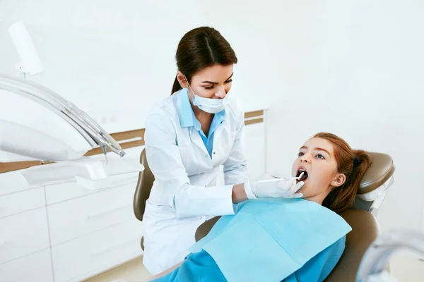 Stomatologii. Dentysta, praca z dziewczyna zębów w klinice stomatologicznej. — Zdjęcie stockowe