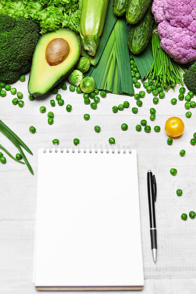 Shopping List. Green Vegetables And Notebook On Table