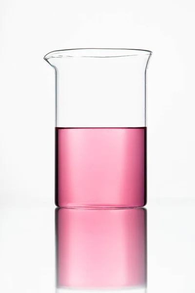 实验室玻璃器皿。白色背景的粉红色液体玻璃 — 图库照片