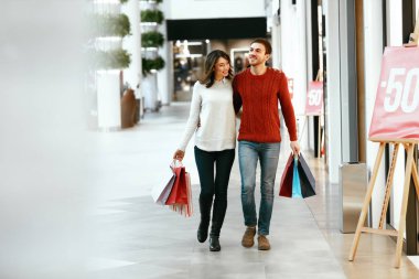 Kaç alışveriş. Mutlu bir adam ve kadın çantaları ile