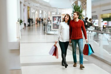 Kaç alışveriş. Mutlu bir adam ve kadın çantaları ile