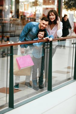 Mutlu aile alışveriş ve alışveriş merkezinde eğleniyor