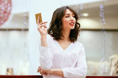 Kredi kartı alışveriş merkezinde tutan kadın