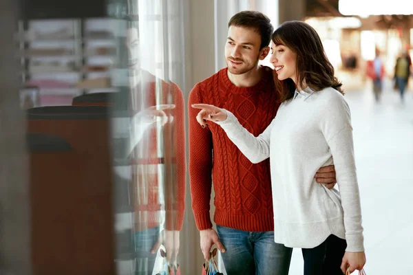 Winkelcentrum. Man en vrouw op zoek door Store raam — Stockfoto