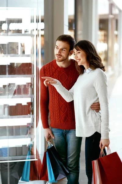 Le centre commercial. Homme et femme regardant à travers la fenêtre du magasin — Photo