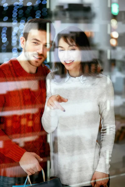 Winkelcentrum. Man en vrouw op zoek door Store raam — Stockfoto