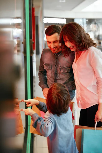 Familia en el centro comercial. Gente mirando por la ventana —  Fotos de Stock