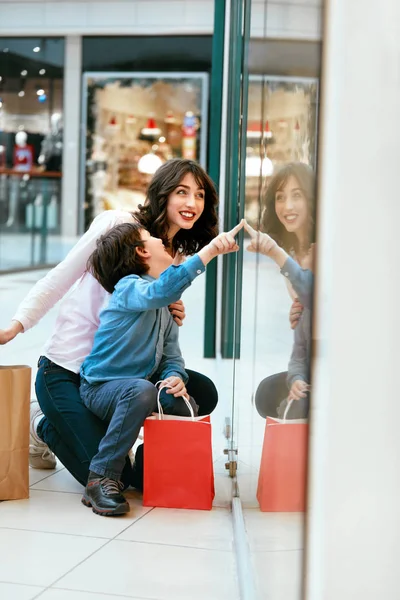 Winkelen. Jonge moeder en kind met zakken In winkelcentrum — Stockfoto