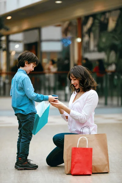 Centre commercial. Un enfant donne des cadeaux à sa mère — Photo