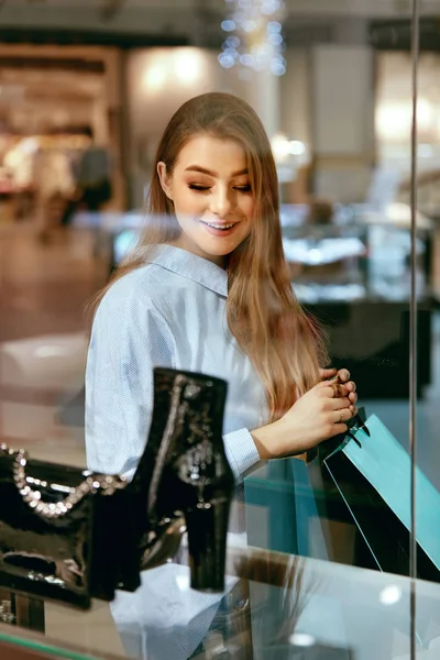 Jonge vrouw op zoek via etalage — Stockfoto