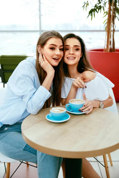 Друзья девушки пьют кофе в кафе — стоковое фото