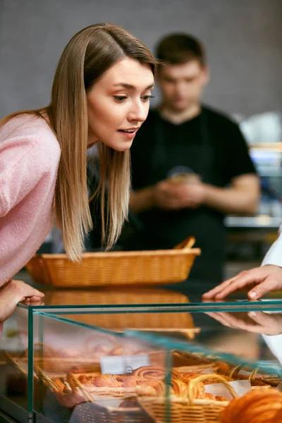 Bakelse. Kvinnan att välja färska bageri i butik. — Stockfoto