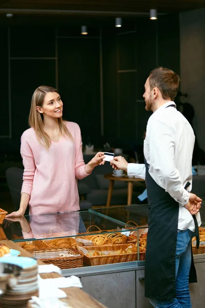 Kvinnan betalar med kreditkort i bageriet — Stockfoto