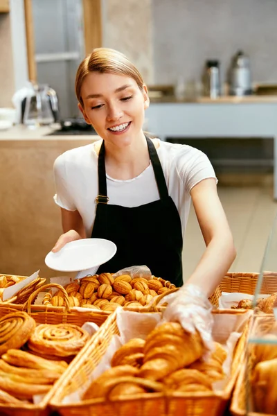 Bageriet. Lycklig kvinna säljer bakverk — Stockfoto