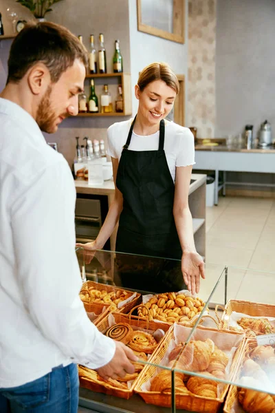 Bageriet. Kvinnan arbetar, sälja bageriet till hane — Stockfoto