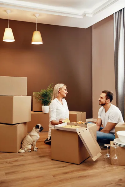 Bewegend. Mann und Frau essen in der Nähe von Kisten — Stockfoto