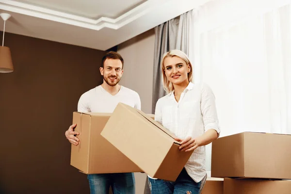 Переезжающий дом. Мужчина и женщина держат коробки — стоковое фото