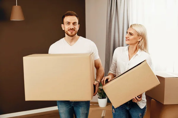 Umzug. Mann und Frau halten Schachteln — Stockfoto
