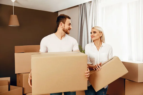 Переезжающий дом. Мужчина и женщина держат коробки — стоковое фото